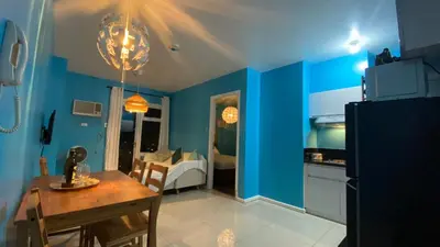 a kitchen and dining room with blue walls and a table at The Radiance Manila in Manila