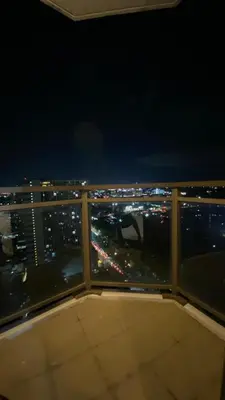 a balcony with a view of the city at night at The Radiance Manila in Manila
