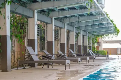 a row of benches next to a swimming pool at EC Suites Modern 1Br Suite w Balcony in Pasay in Manila