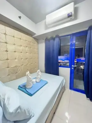 a bedroom with a bed with shoes on a blue tray at Sojourn at Sea Residences MOA in Manila