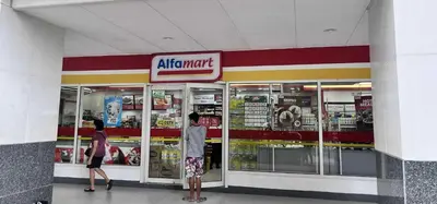 two people standing in front of an air mart store at Sojourn at Sea Residences MOA in Manila