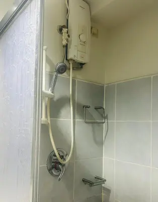 a shower in a bathroom with a hair dryer at Sojourn at Sea Residences MOA in Manila