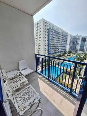 a balcony with chairs and a view of a building at Sojourn at Sea Residences MOA in Manila
