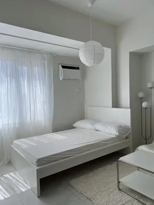 a white bedroom with a bed and a window at Cloud Space Studio near Eastwood in Manila