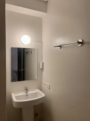 a white bathroom with a sink and a mirror at Cloud Space Studio near Eastwood in Manila