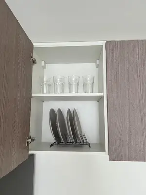 a cupboard with bowls and glasses in it at Cloud Space Studio near Eastwood in Manila