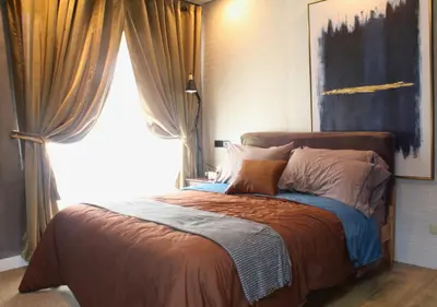 a bedroom with a bed with a large window at The Brass Burrow, Bel Air Soho Suites in Manila