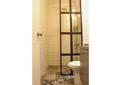 a bathroom with a shower and a toilet at The Brass Burrow, Bel Air Soho Suites in Manila