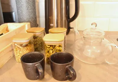 a kitchen counter with two cups and jars of food at The Brass Burrow, Bel Air Soho Suites in Manila