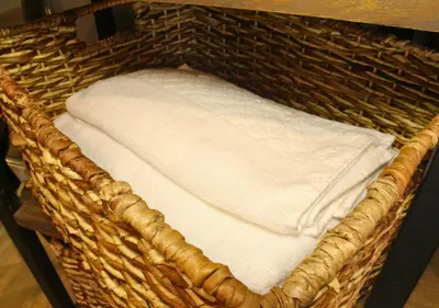 a basket filled with white towels on a table at The Brass Burrow, Bel Air Soho Suites in Manila