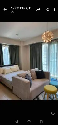 a living room with a couch and a table at Romeotwopalmtreevilla in Manila