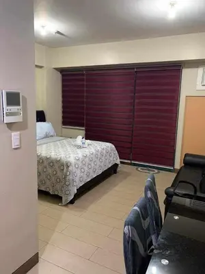 a bedroom with a bed and a large window at Romeotwopalmtreevilla in Manila