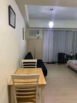 a living room with a table and a couch at Romeotwopalmtreevilla in Manila
