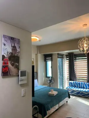 a bedroom with a green bed and a couch at Romeotwopalmtreevilla in Manila
