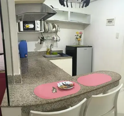 a kitchen with a pink counter top and a table at Modern Studio Birch Tower Near Malls & Nightlife in Manila