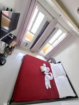 a bedroom with a red bed with a teddy bear on it at Modern Studio Birch Tower Near Malls & Nightlife in Manila