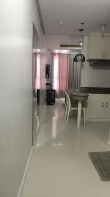 a white kitchen with a table and a dining room at Modern Studio Birch Tower Near Malls & Nightlife in Manila