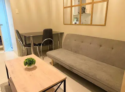 a living room with a couch and a table at The Nook Stays at Sea Residences in Manila