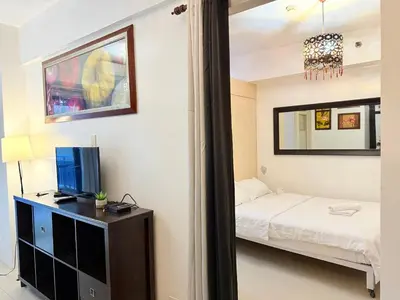 a bedroom with a bed and a tv on a dresser at The Nook Stays at Sea Residences in Manila