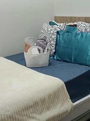 a bed with blue sheets and pillows in a room at CozyStay by MA-Coast Residences in Manila