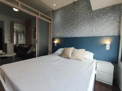 a bedroom with a large white bed with a blue wall at Newly Designed 1BR Top of Makati in Manila