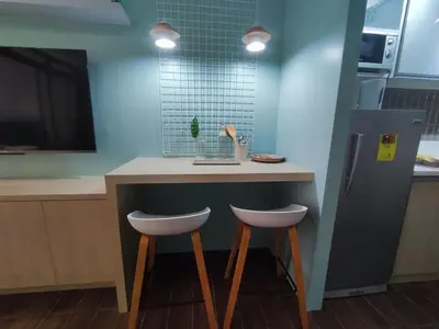 a kitchen with a counter with two stools at a bar at Newly Designed 1BR Top of Makati in Manila