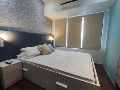a small bedroom with a bed with a window at Newly Designed 1BR Top of Makati in Manila