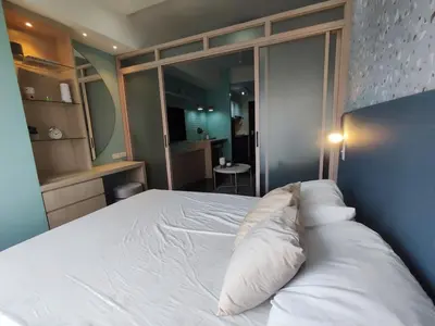 a bed with two pillows on it in a room at Newly Designed 1BR Top of Makati in Manila
