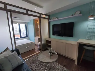a living room with a couch and a tv at Newly Designed 1BR Top of Makati in Manila