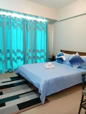 a bedroom with a blue bed with blue curtains at Jace Oasis in Manila