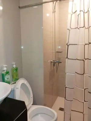 a bathroom with a shower with a toilet and a sink at Jace Oasis in Manila