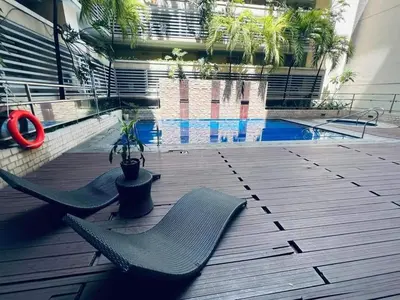 a deck with two chairs and a swimming pool at Jace Oasis in Manila