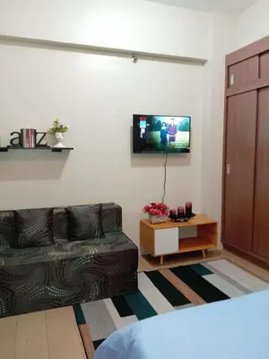 a living room with a couch and a tv at Jace Oasis in Manila