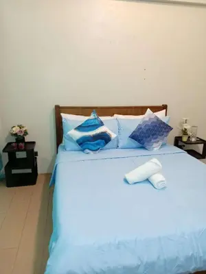 a bed with blue sheets and pillows at Jace Oasis in Manila
