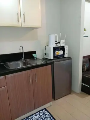 a kitchen with a sink and a microwave at Jace Oasis in Manila