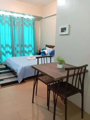 a room with a bed and a table and chairs at Jace Oasis in Manila