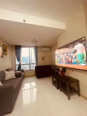 a living room with a couch and a flat screen tv at Cozy Studio Unit located at serene area in Manila