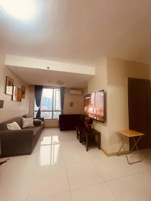 a living room with a couch and a flat screen tv at Cozy Studio Unit located at serene area in Manila