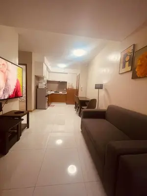 a living room with a couch and a flat screen tv at Cozy Studio Unit located at serene area in Manila