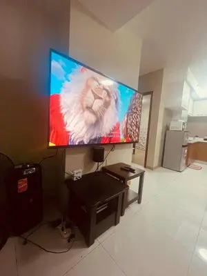 a flat screen tv hanging on a wall in a living room at Cozy Studio Unit located at serene area in Manila