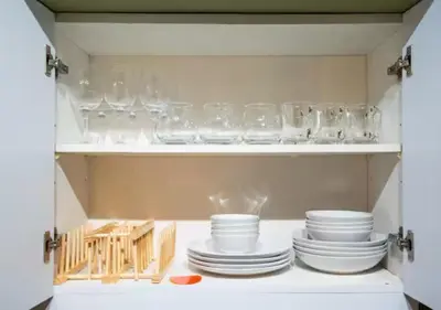 a cupboard filled with glasses and plates and bowls at Villa Verde, Tivoli Garden Residences in Manila