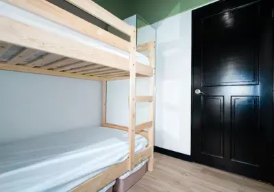 a room with two bunk beds and a black door at Villa Verde, Tivoli Garden Residences in Manila