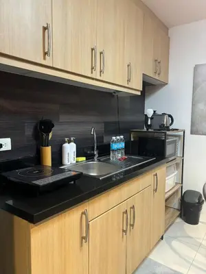 a kitchen with a sink and a microwave at Cozy studio unit in Avant BG in Manila