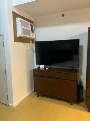 a flat screen tv sitting on top of a dresser at Cozy studio unit in Avant BG in Manila