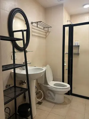 a bathroom with a toilet and a sink and a mirror at Cozy studio unit in Avant BG in Manila