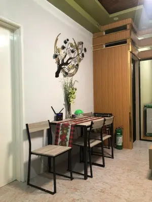 a dining room table with chairs and a chandelier at South Sanctuary in Manila