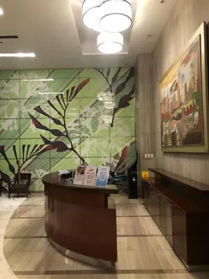 a lobby with a reception desk and a large mural at South Sanctuary in Manila