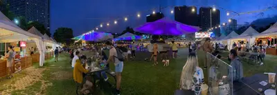 a crowd of people sitting in the grass at a festival at CityHomeStay in Manila