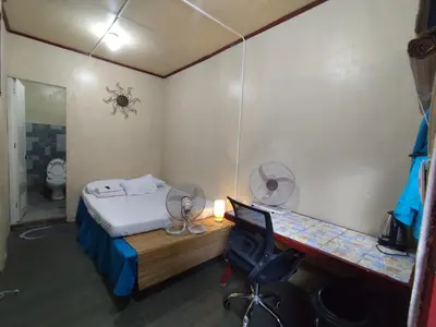 a small room with a bed and a desk with a desk at TerisitaPlace - BamboRoom in Taytay