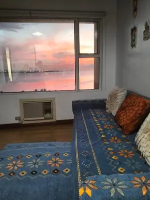 a bedroom with a window with a view of the ocean at Chic Haven in Manila